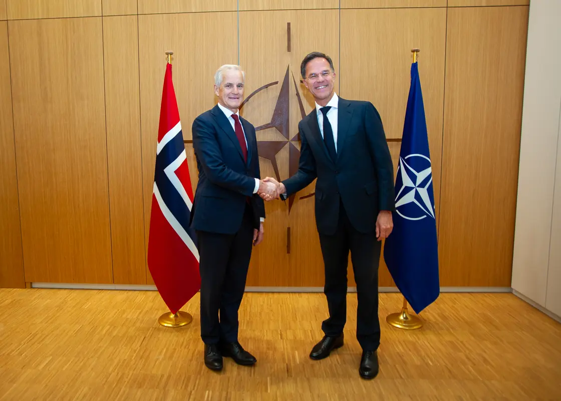 Støre og Rutte med håndtrykk foran Norge- og Nato-flagg