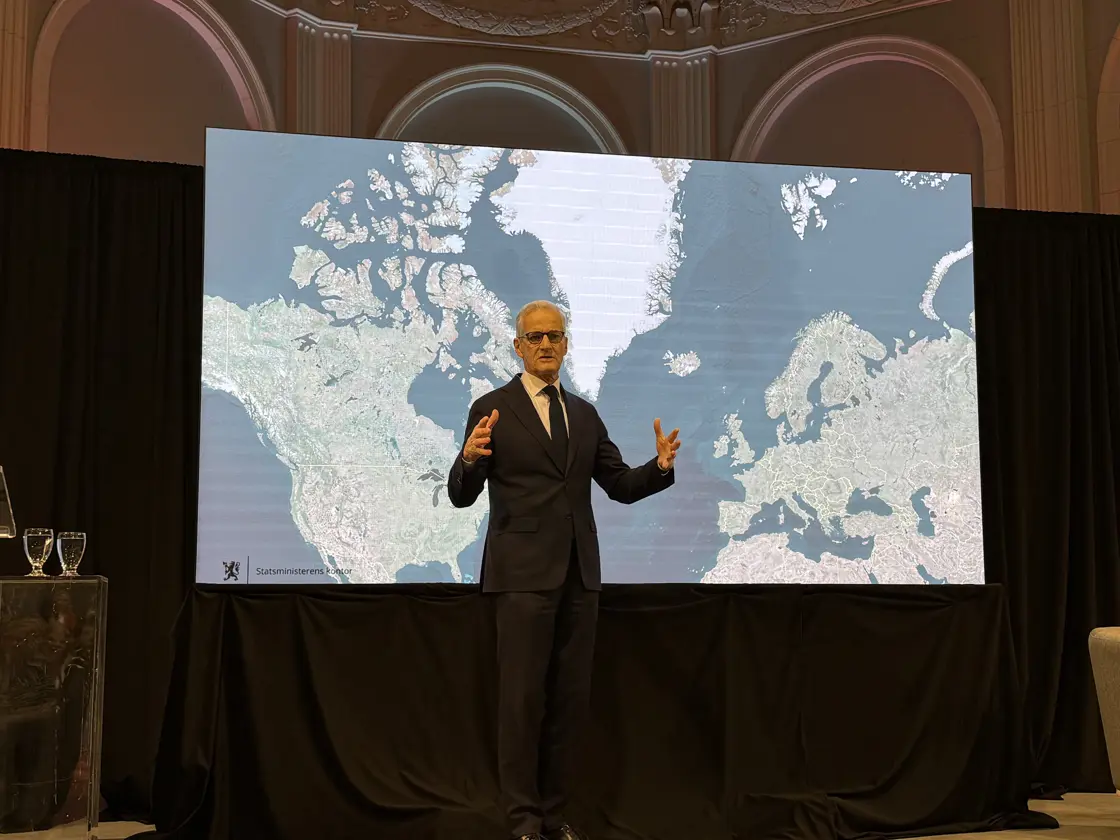 Prime Minister Støre in front of a map of the Arctic.