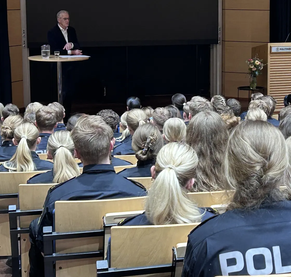 Auditorium med politistudenter. Støre står lengst unna kamera - på scenen.