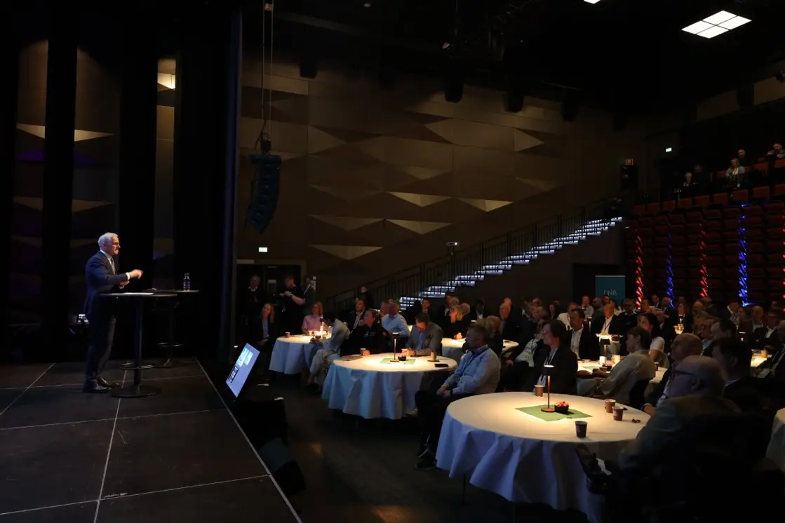 Statsministeren står på scenen, bildet viser en del av deltakerne som sitter i salen