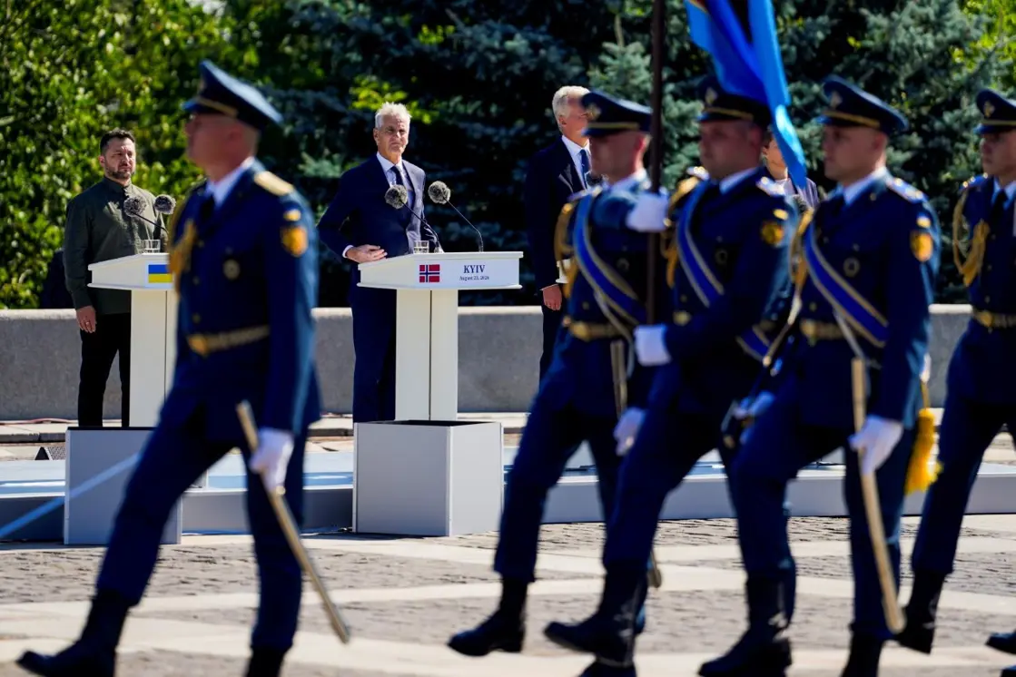 Soldiers marching in front of Zelenskyj and Støre. 