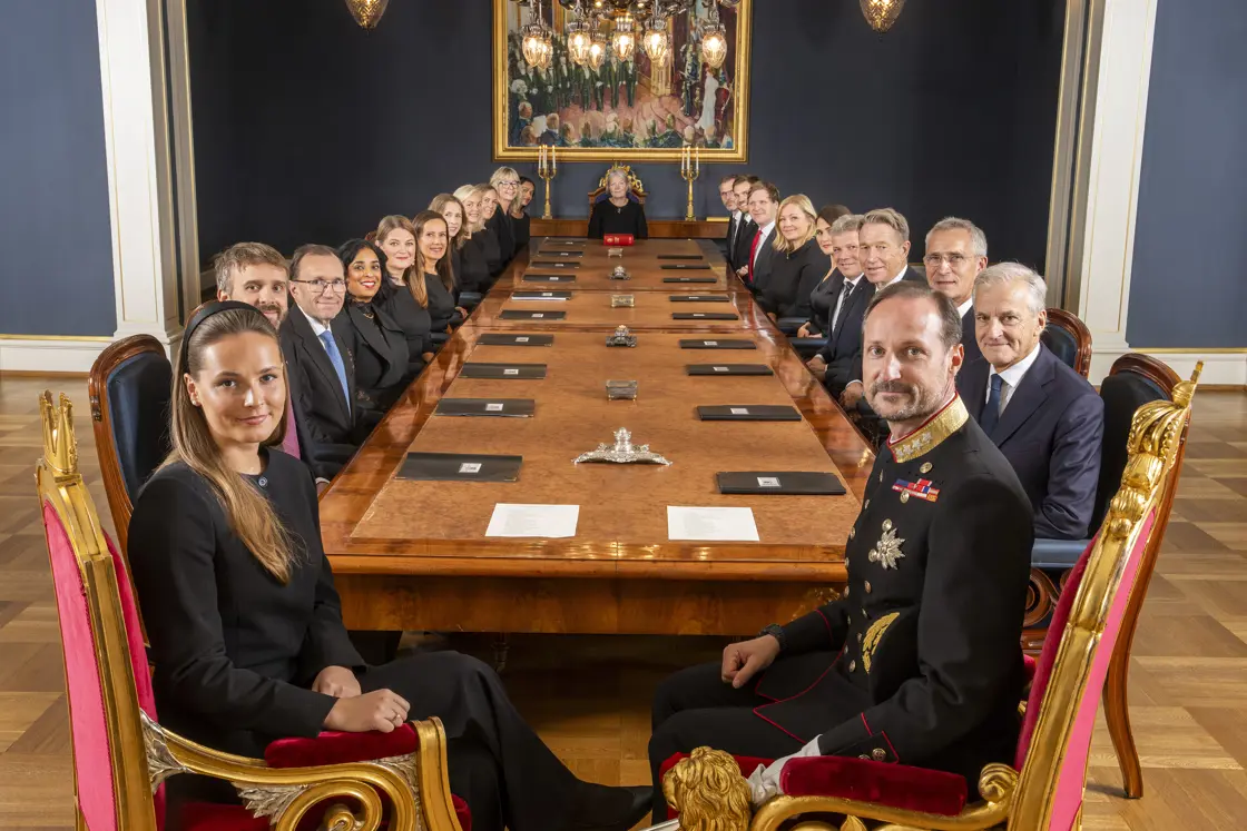 Kong Haakon VIII, kronprinsesse Ingrid Alexandra og regjeringen rundt møtebordet i statsrådssalen på Slottet.