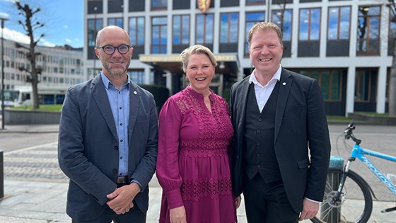 Bilde av Norec-direktør, Tvinnereim og Gjelsvik utendørs foran inngangen til UD. 