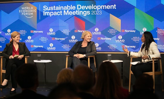 Bilde av panel på scene bestående av tre personer sittende, utviklingsminister Tvinnereim i midten
