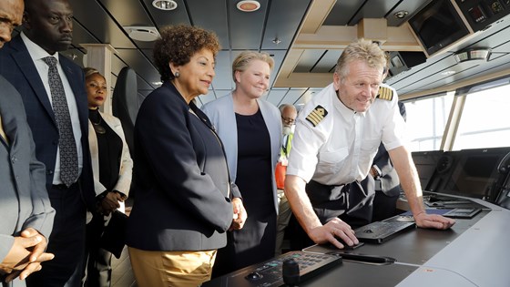Bilde av kaptein og utviklingsminister Tvinnereim med flere på broen på et forskningsskip