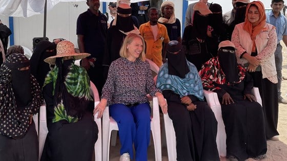Bilde av utenriksminister Huitfeldt sammen med kvinner i flyktningeleir