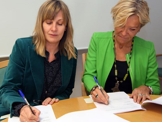 Avdelingsdirektør Hilde Haraldstad og Liv Tørres fra Norsk Folkehjelp signerer den nye avtalen.