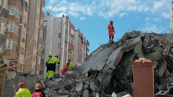 Bilde av redningsarbeidere som jobber i store ruiner