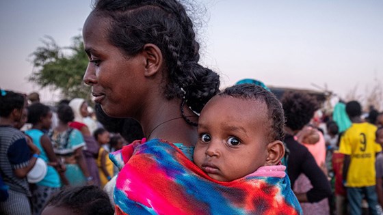En mor står i kø for å få mat i en flyktningleir i Sudan. FN anslår at rundt 61 000 mennesker har flyktet fra Tigray-regionen til nabolandet Sudan. Foto: Joost Bastmeijer, WFP/Arete