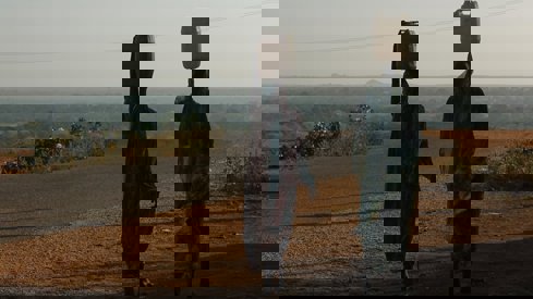 To damer som går med vannkanner på hodet