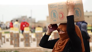  A woman collects food in Deir Hafer, 60 km from Aleppo in Syria. WFP is working with the Syrian Arab Red Crescent to distribute food to the most vulnerable.