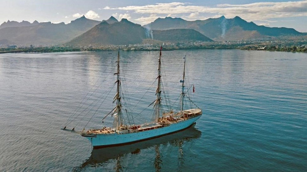 Bilde av skipet med fjell i bakgrunnen. 