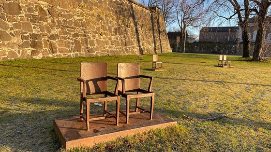 There are eight empty chairs arranged singly or in pairs on the grass outside Akershus Fortress. Credit: Guri Solberg, MFA