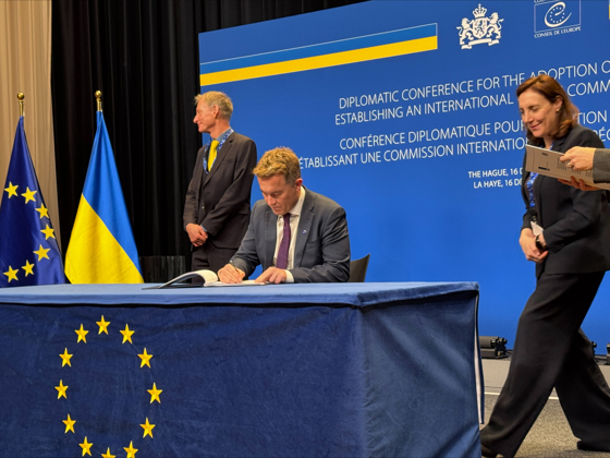 Statssekretæren signerer avtale på scene