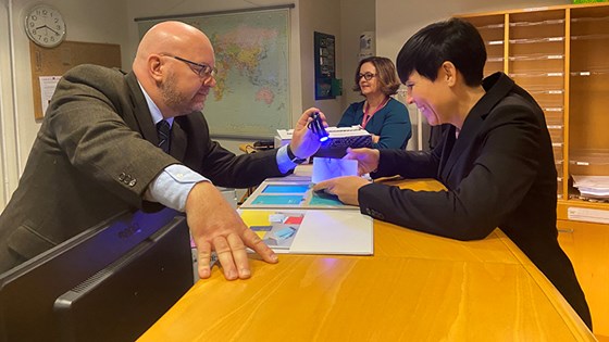 Utenriksministerens nye pass blir testet for UV-lys. Foto: Guri Solberg, UD
