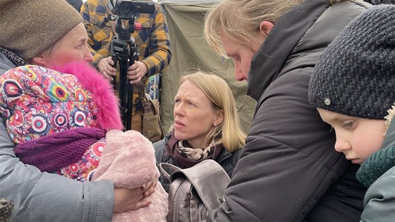 Utenriksministeren snakker med en kvinne med et barn