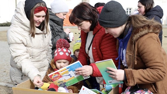 Tre voksne og et barn ser på bøker