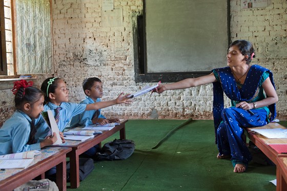 Teacher assists blind children at school in Nepal