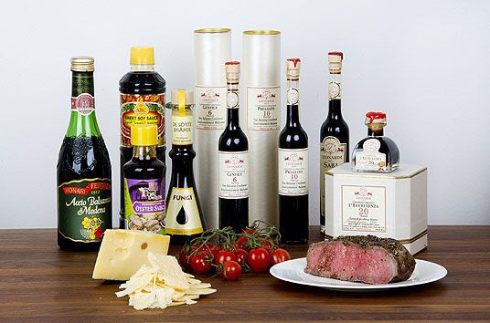 Bildet viser typiske kilder for smaken umami; vellagret balsamico eddik finnet på opptil 30 år finnes i velutstyrte kolonialbutikker,  soyasaus, vellagrede oster som Jarlsberg og Parmesan. Andre kilder er stekt oksekjøtt og tomater.
