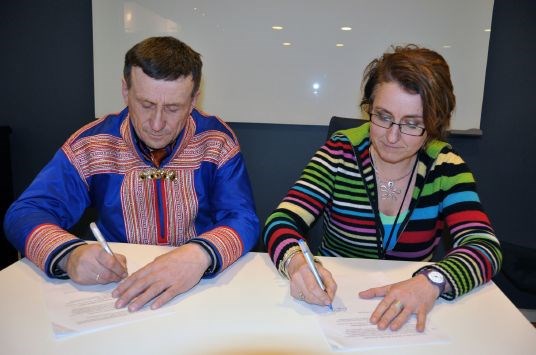 Norske Reindriftsamers Landsforbund forhandlingsleder Nils Henrik Sara og Statens forhandlingsleder konstituert ekspedisjonssjef Anne Marie Glosli signerer avtalen.