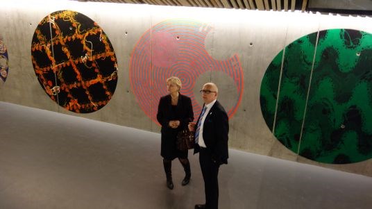 Kulturminister Thorhild Widvey og rådmann i Hamar Martin W. Kulild i foajeen med kunstverk av Nils Erik Gjerdevik på veggene.
