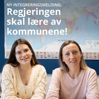 To smilende damer foran et verdenskart i et klasserom