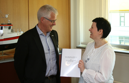 Fiskeri- og kystminister Helga Pedersen mottar Fiskeridirektoratets høringsnotat om kysttorskforvaltning på Vestlandet og langs Skagerakkysten fra avdelingsdirektør Aksel Eikemo