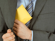 Mann putter en brun konvolutt i lommen. Foto: Darek Niedzieski, iStock