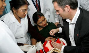 Statsminister Jens Stoltenberg gir en oral polivaksine til et barn på et sykehus i New Dehli India