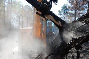 Skogbrannen på Konnerud i Drammen var stedvis så intens at trerøttene ble brent av. Slike ustabile trær ble lagt i bakken ved hjelp av en gravemaskin.  Foto: Rune Groven.
