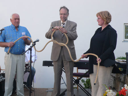Departementsråd Per Harald Grue knyttet sammen det symbolske tauet mellom Hans Lindsveen fra Apelsvoll og Unni Myrheim fra Kise. Foto: LMD