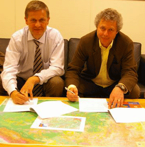 Erik Solheim (tv) og Lars Løvold undertegner avtalen om støtte til Regnskogfondet. Foto: Mette Andersen, UD