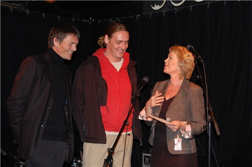 Statsråd Åslaug Haga overrekker tilsagnsbrevet på 1,2 millioner kroner til prosjektleder Ivar Mykland i Nisjelandet (t.v.) og by:larmleder Erlend Mogård-Larsen.