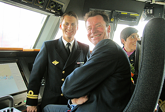 Statssekretær Roger Ingebrigtsen og gudmor, leder av utenriks- og forsvarskomiteen på Stortinget, Ine Marie Eriksen Søreide får orientering av løytnant Chris Petter Haukedal på broen på KNM ”Storm”. - Foto: Forsvarsdepartementet