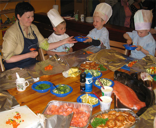 Fiskeri- og kystminister Helga Pedersen lager sjømat sammen med barn i Slettebakken barnehage i Bergen. Foto: Fiskeri- og kystdepartementet